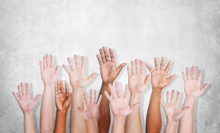 Hands of diverse ethnicity raising