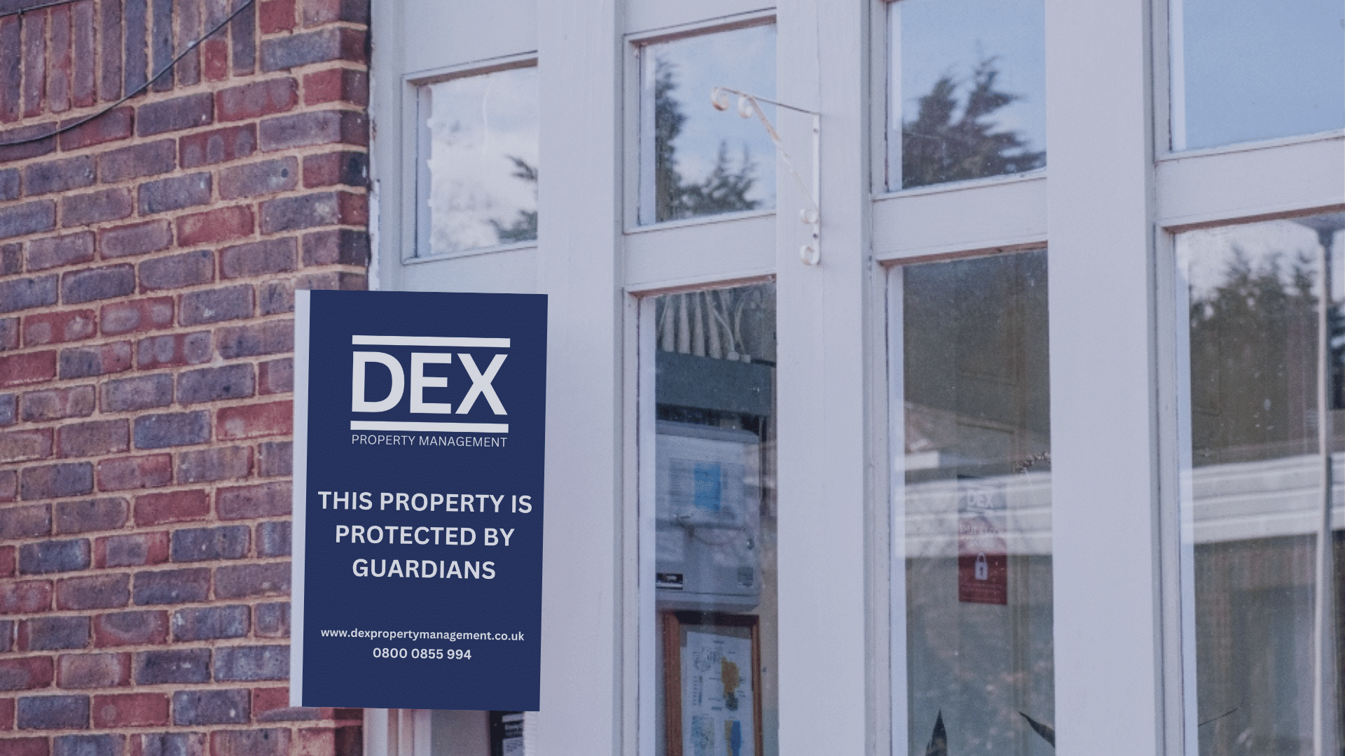 A sign on a building which says the building is secured by DEX guardians.